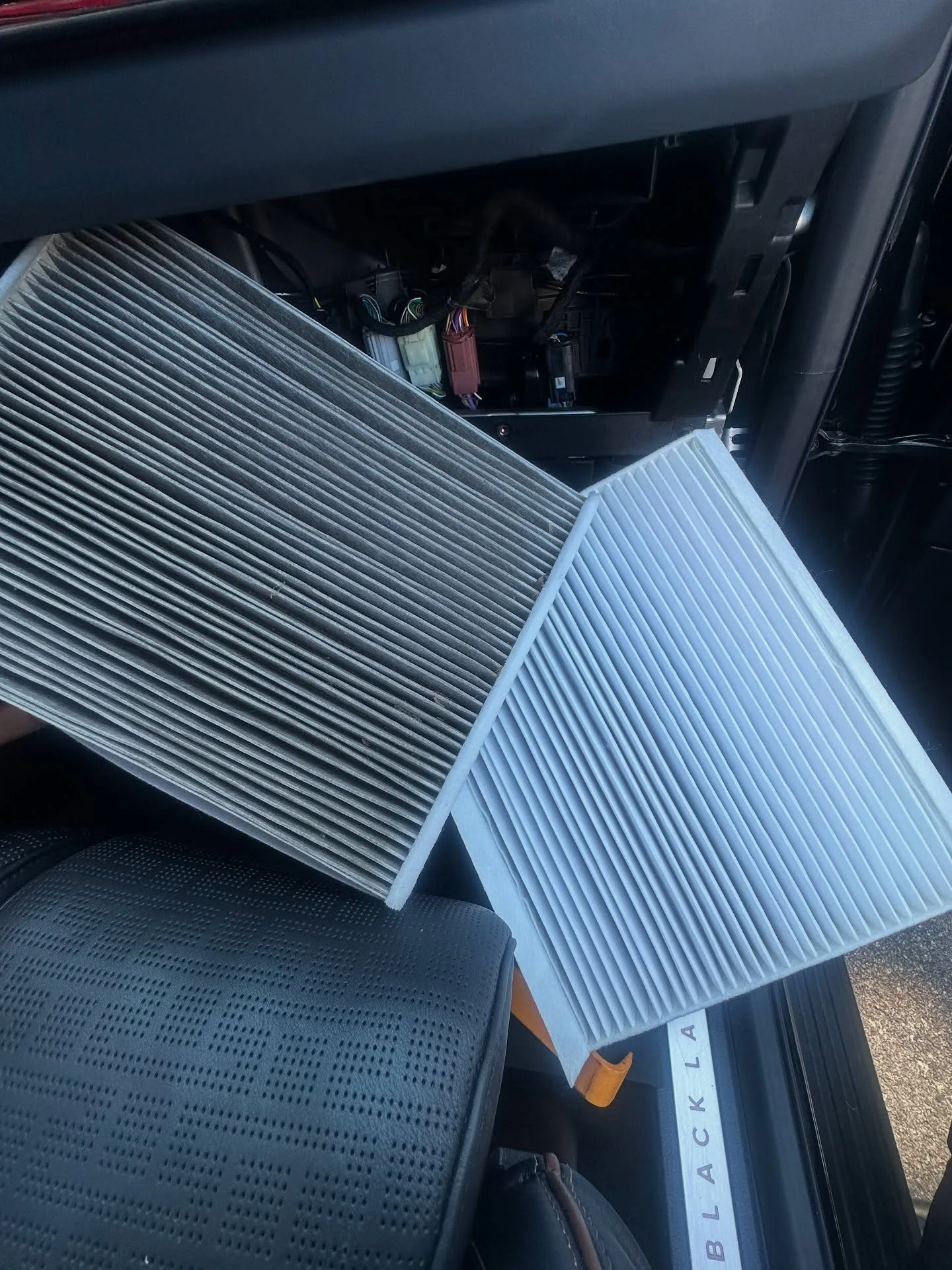 Used cabin air filter beside a clean replacement filter