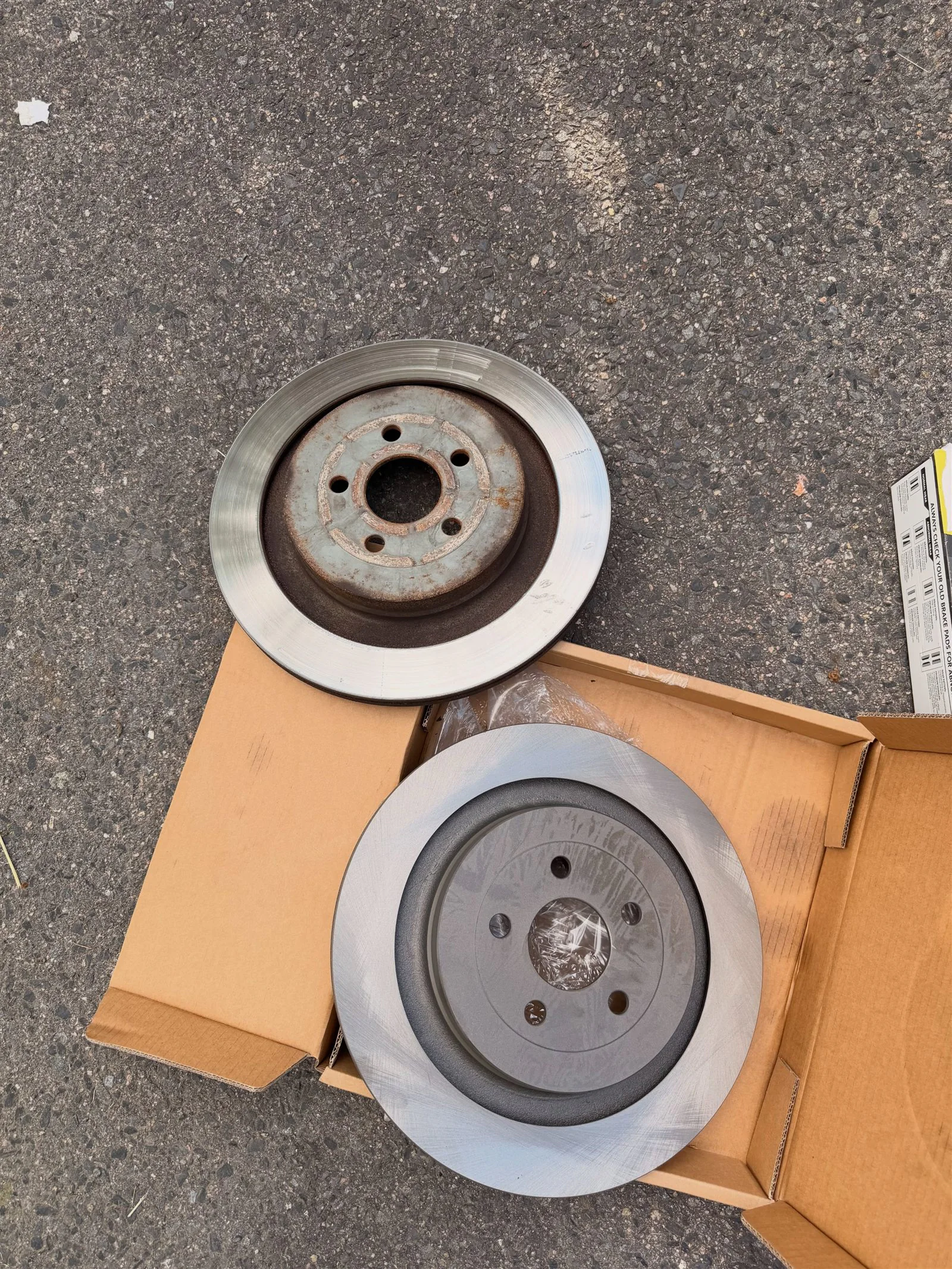 Worn and new rear brake rotors for a 2022 Lincoln Nautilus